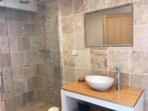 a bathroom with a sink and a shower with a mirror at Le Mas du Pigeonnier in Réauville +28 photos