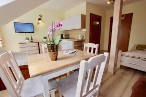 a kitchen with a wooden table with a vase of flowers on it at Willa Helios in Darlowko