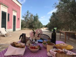 a picnic table with food and a bottle of wine at The Aia in Nardò