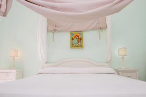 ヴィエステにあるYourvacanza Vieste Mon Amourのベッドルーム(ピンクの天蓋付き白いベッド1台付)