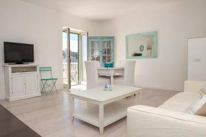 a living room with a white couch and a table at Opera Dimore in Vieste