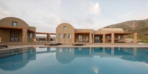 uma casa com piscina em frente a uma montanha em Cellaria Estate Exclusive em Vlychada
