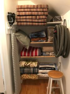 a closet filled with lots of blankets and a stool at La Maison des Éboulis in Victoriaville