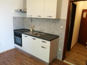 a kitchen with white cabinets and a sink at Ivanka Apartments in Vrboska