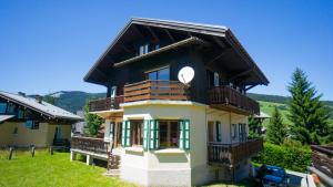 a house with a balcony and a clock on it at Les Clochettes in Megève