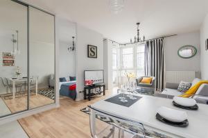 a living room with a table and a dining room at KLOBUCKA P&O Serviced Apartments in Warsaw