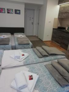 a room with four beds with towels on them at Apartman Centar 1 in Užice