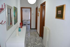 a hallway with white walls and a hallway with paintings at Cà da Lalla Maria in Noli