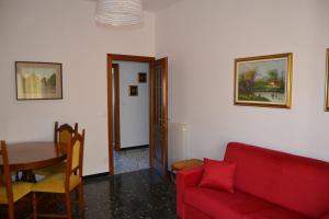 a living room with a red couch and a table at Cà da Lalla Maria in Noli