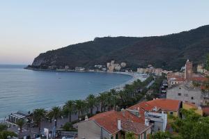 a view of a beach with palm trees and houses at Cà da Lalla Maria in Noli