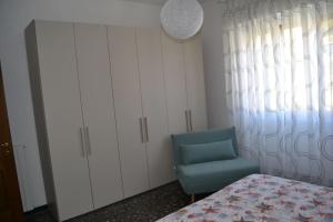 a bedroom with a bed and a blue chair at Cà da Lalla Maria in Noli