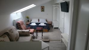 a living room with a bed and a couch at Guest House Villa Herbarium in Slavonski Brod