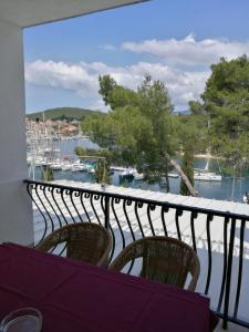 a balcony with two chairs and a view of a marina at Ivanka Apartments in Vrboska