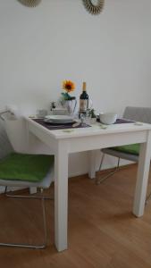 einen weißen Tisch mit 2 Stühlen und einen Tisch mit Tellern in der Unterkunft Apartment Ana in Split