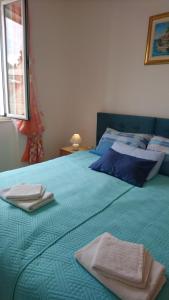 ein Schlafzimmer mit einem blauen Bett mit Handtüchern darauf in der Unterkunft Apartment Ana in Split