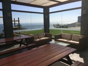 salon z kanapami i stołem oraz widokiem na ocean w obiekcie Apartamento Eluchans Reñaca w mieście Viña del Mar
