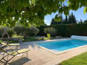 einen Pool im Garten mit zwei Stühlen und einem Tisch in der Unterkunft Le Mazet Des Joncs en Provence in Saint-Pierre-de-Vassols