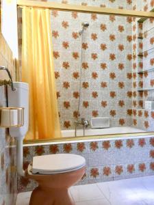 une salle de bain avec toilettes et un rideau de douche jaune dans l'établissement Cascais Seaside Garden Villa, à Cascais 79 autres photos
