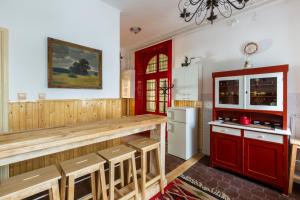 Il comprend une cuisine équipée de placards rouges et d'un réfrigérateur blanc. dans l'établissement Vintage Home in the Center, à Budapest