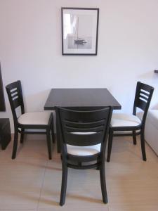 a black table with two chairs and a table and a picture at Apartments Danilo Kažanegra in Sveti Stefan