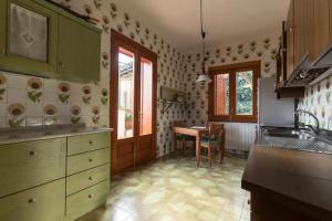 a kitchen with green cabinets and a table at Villa 'Nduccia in Pedara