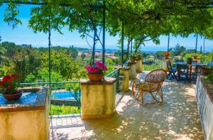 a patio with a table and chairs on a balcony at Villa 'Nduccia in Pedara