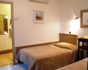 Ένα ή περισσότερα κρεβάτια σε δωμάτιο στο Logis Hôtel Restaurant Les Capucins