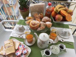 a table with a breakfast of pastries and orange juice at La Fenice in Salerno +22 photos