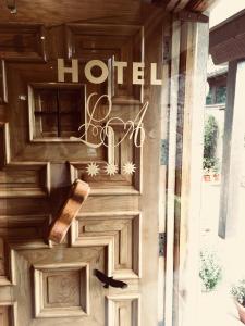 - une porte en bois avec un panneau d'hôtel dans l'établissement Hotel La Arquera, à Llanes