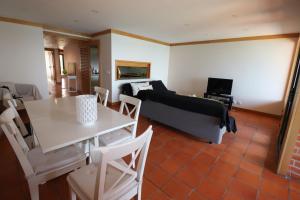 ein Wohnzimmer mit einem Sofa und einem Tisch in der Unterkunft Casa S. José in Sesimbra