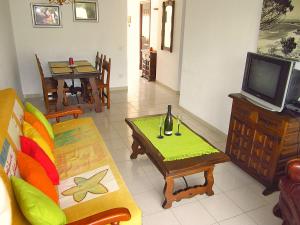ein Wohnzimmer mit einem Sofa, einem Tisch und einem TV in der Unterkunft Playa Dorada B106 in Cambrils