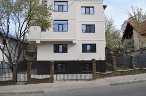 a white house with a black fence at YNS Apartaments in Iaşi