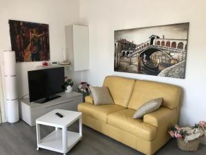 uma sala de estar com um sofá e uma televisão em Casa Clara em Altavilla Vicentina