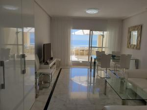 ベナルマデナにあるMagnifico Sea View Apartment Costa del Solのリビングルーム(テレビ、テーブル、椅子付)