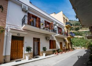 ein Gebäude mit Balkonen und Topfpflanzen auf einer Straße in der Unterkunft Casa dei Coralli in Castellammare del Golfo