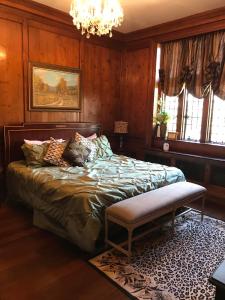 a bedroom with a bed and a chandelier at The Castle at Skylands Manor in Ringwood