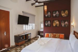 a bedroom with a large bed and a flat screen tv at Hotel Urban in Mérida
