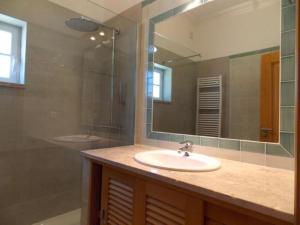 a bathroom with a sink and a mirror at Praia Del Rei Beach 3 Pools in Amoreira +13 photos
