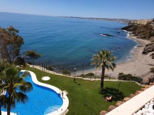 ベナルマデナにあるMagnifico Sea View Apartment Costa del Solのスイミングプールとビーチの景色を望めます。