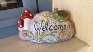 a rock with a welcome sign on a wall at Zach's house in Nea Roda