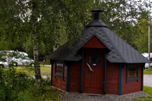 a small red house with a black roof at Fauske Camping & Motel in Fauske +4 photos