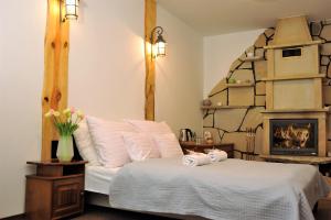 a bedroom with a bed and a fireplace at Hotel Protea Bolesławiec in Bolesławiec