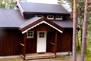 a small wooden house with a wooden door at Fauske Camping & Motel in Fauske