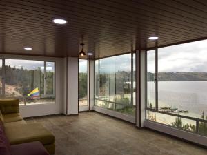 a living room with large windows and a view of a lake at El Arca de Noah in Tota
