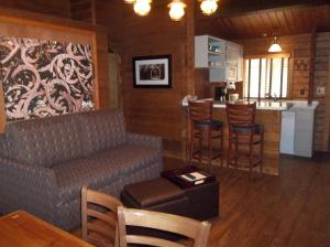 a living room with a couch and a kitchen at Kohl's Ranch Lodge in Payson