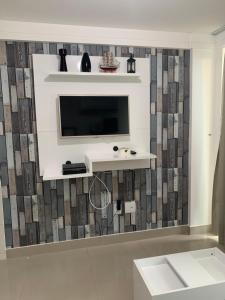 a living room with a television on a wall at Flat vista mar de Intermares completíssimo 508 in João Pessoa