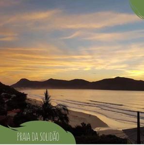 uma vista para uma praia com o oceano e as montanhas em Residencial Caminho das Pedras - Praia da Solidão em Florianópolis