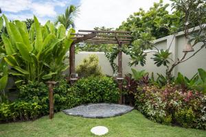 a garden with a pergola and green plants at Pondok Santi Estate in Gili Trawangan