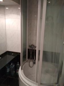 um chuveiro com uma porta de vidro na casa de banho em Готель на Автовокзалі em Poltava
