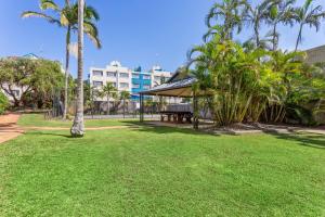 a park bench in the middle of a grassy area at Kalua Holiday Apartments in Maroochydore